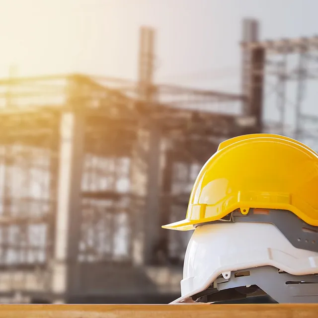 Gul og hvit hjelm på byggeplass